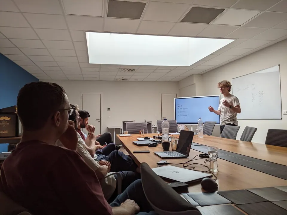Ruben Thielman presenteert de agenda van een AI-workshop aan een team rond een vergadertafel